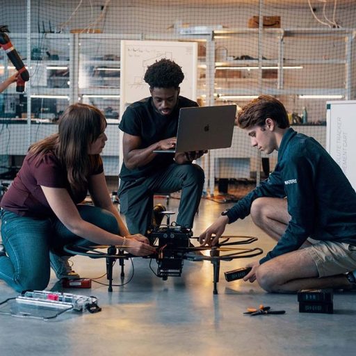 Three students working on a robot in an Engineering lab